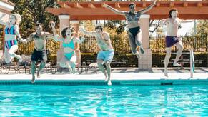 group of friends jumping into a pool surrounded with a pool fence in the background in Markham, Ontario