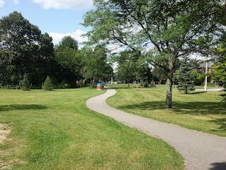 Asphalt pathway lined by grass and trees in Raymerville-Markville East, Markham, Ontario