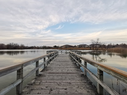 Wooden boardwalk leading to body of water in Greensborough, Markham, Ontario