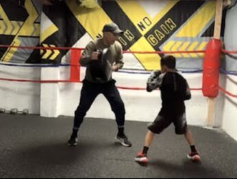Boxing teacher practicing boxing with a student in Wismer Commons, Markham, Ontario